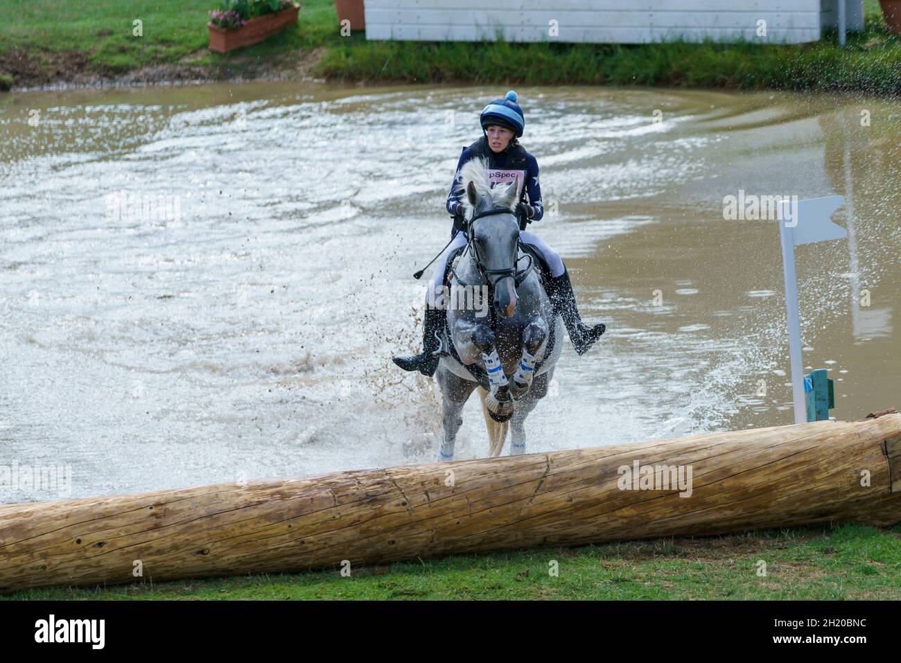 Cavallo e pilota che prende il corso di cross country e salta d'acqua in un'evocante competizione a Gloucestershire, Regno Unito, nel 2018. Foto Stock