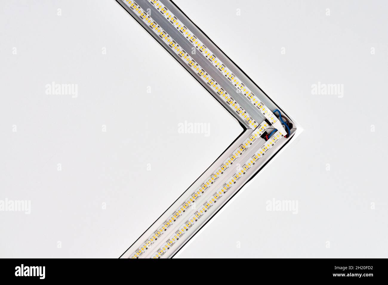 Lampada a striscia a LED con profilo quadrato in alluminio su controsoffitto in casa, frammento, primo piano. Ristrutturazione e ristrutturazione della casa. Energia Foto Stock