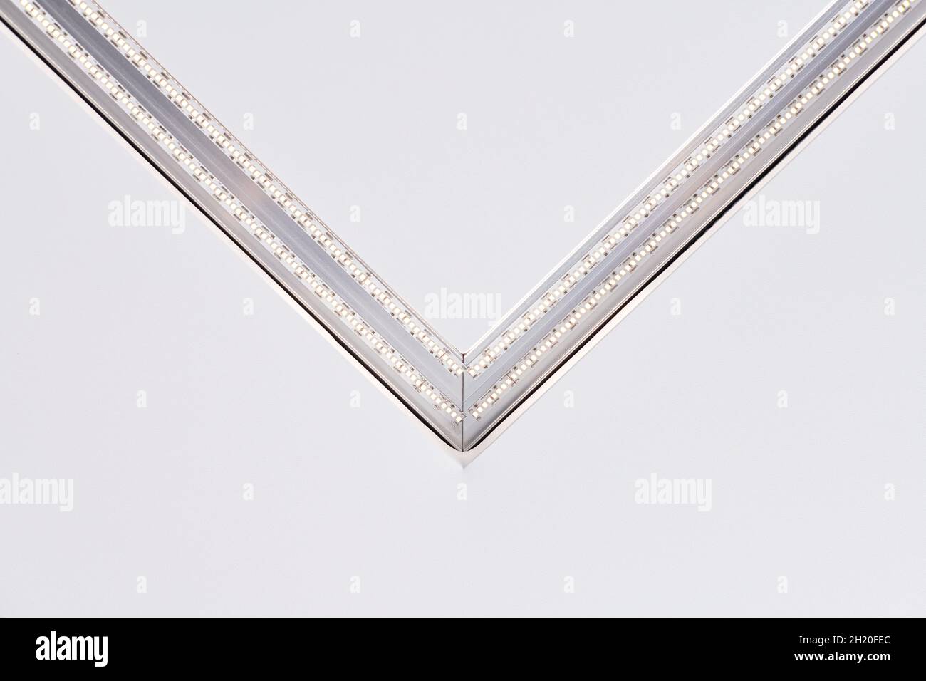 Lampada a striscia a LED con profilo quadrato in alluminio su controsoffitto in casa, frammento, primo piano. Ristrutturazione e ristrutturazione della casa. Energia Foto Stock