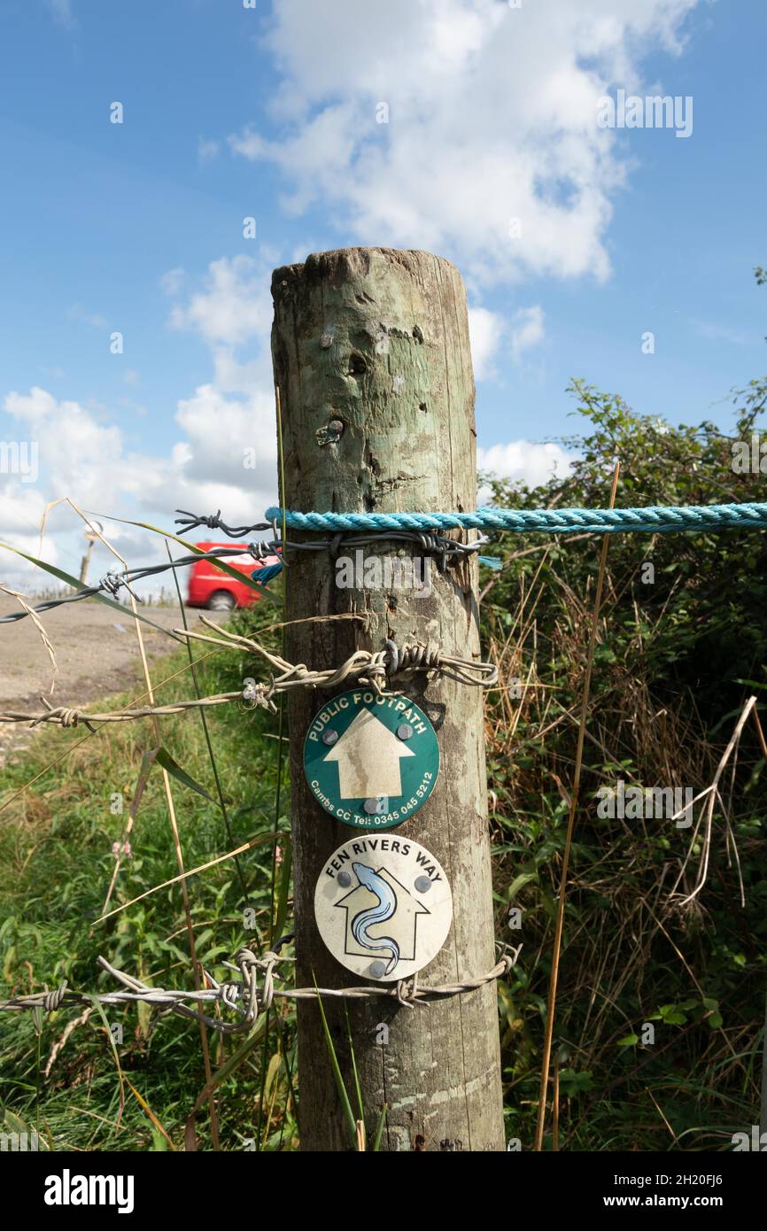 Primo piano di Fen Rivers Way con logo Eel e cartelli con frecce per il sentiero pubblico su palo di legno con filo spinato Cambridgeshire Inghilterra Foto Stock