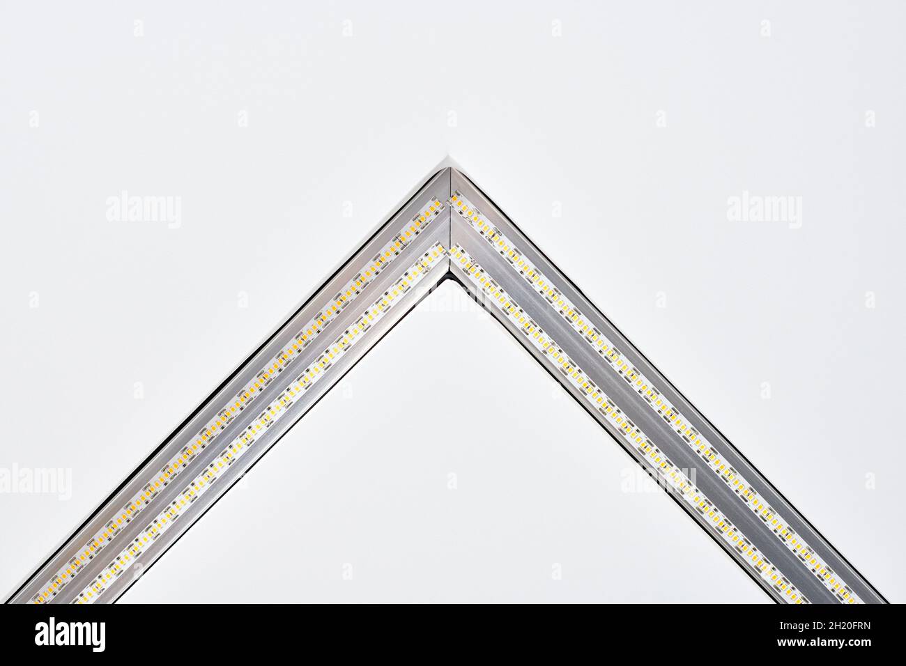 Lampada a striscia a LED con profilo quadrato in alluminio su controsoffitto in casa, frammento, primo piano. Ristrutturazione e ristrutturazione della casa. Energia Foto Stock