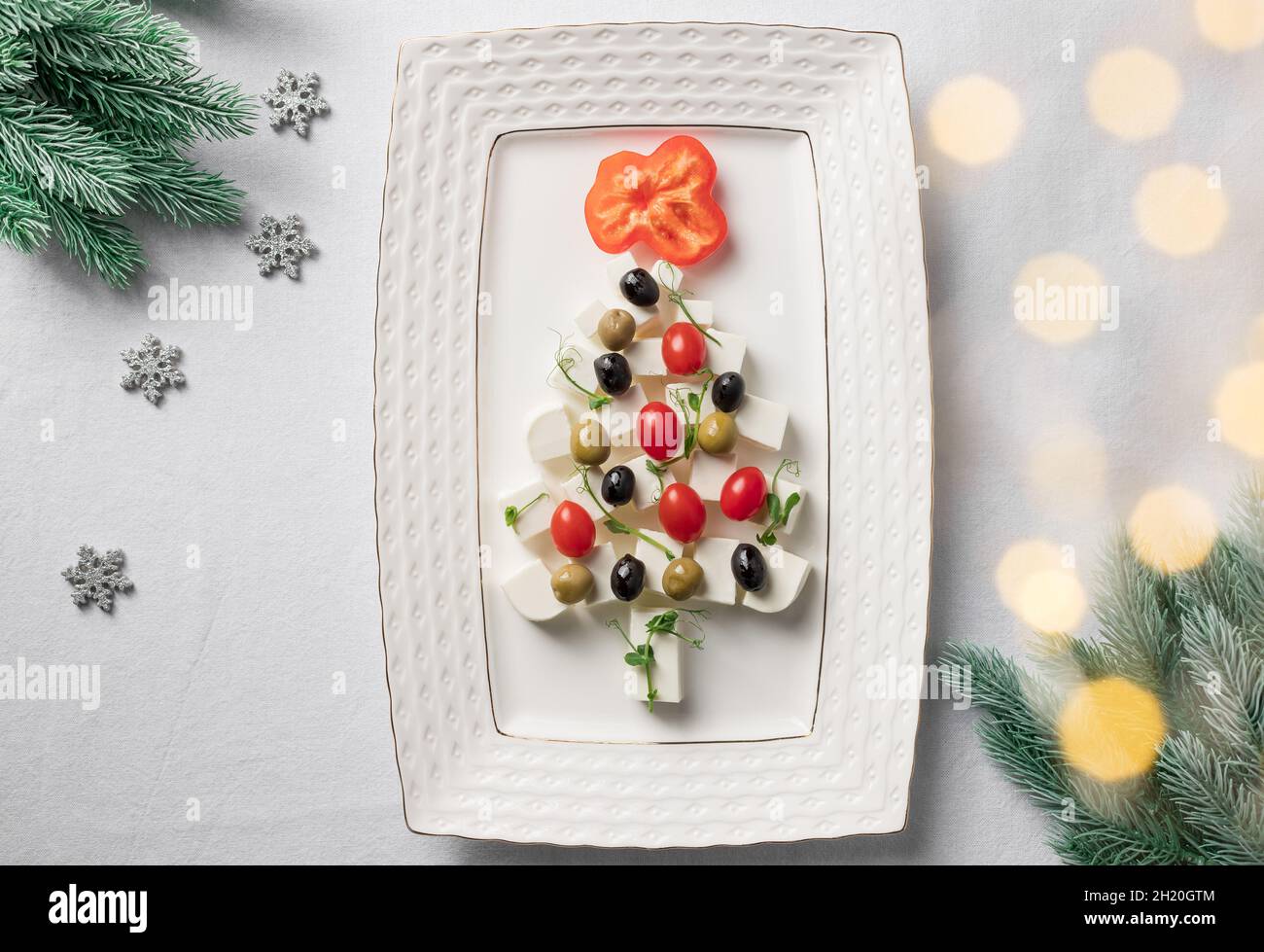 Antipasto sano di Natale, rami di abete su tovaglia bianca Foto Stock