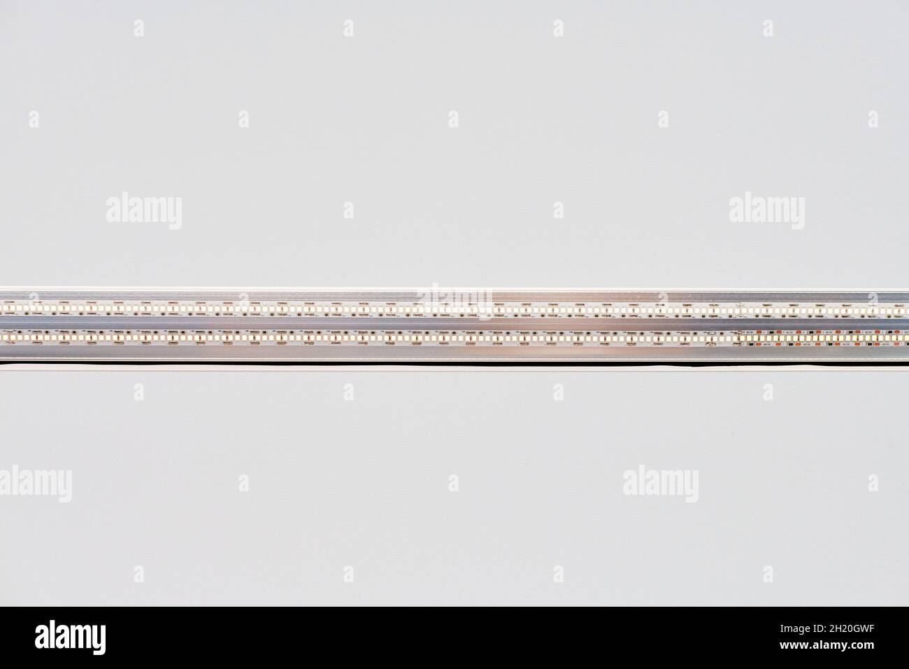 Lampada a LED a striscia con profilo in alluminio su soffitto bianco stretch in casa o in appartamento, da interno in primo piano. Concetto di ristrutturazione della casa. Costruzione moderna, e. Foto Stock