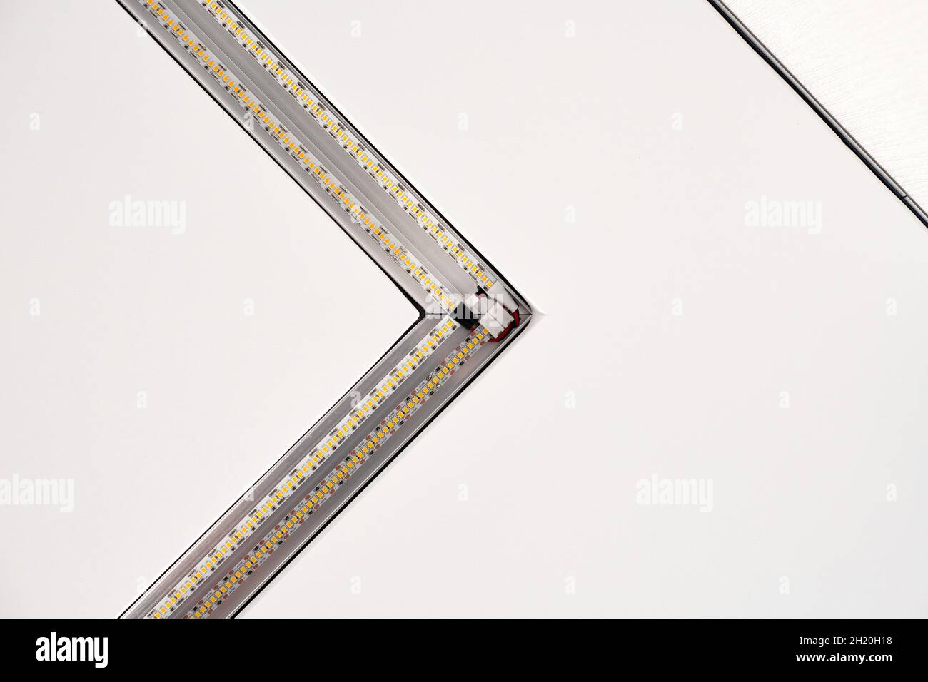 Lampada a striscia a LED con profilo quadrato in alluminio su controsoffitto in casa, frammento, primo piano. Ristrutturazione e ristrutturazione della casa. Energia Foto Stock