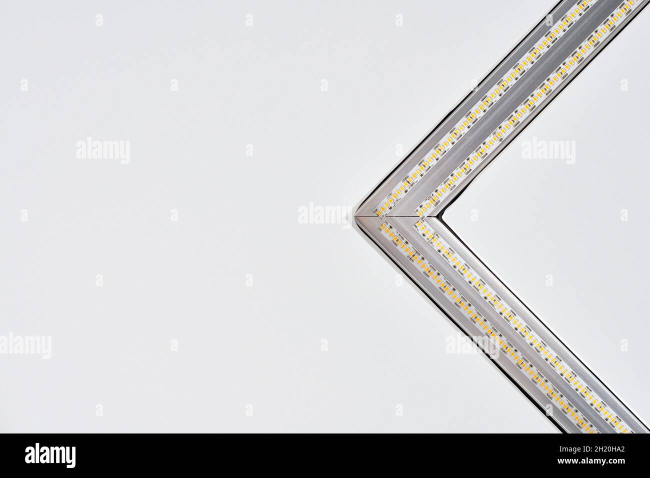 Lampada a striscia a LED con profilo quadrato in alluminio su controsoffitto in casa, frammento, primo piano. Ristrutturazione e ristrutturazione della casa. Energia Foto Stock