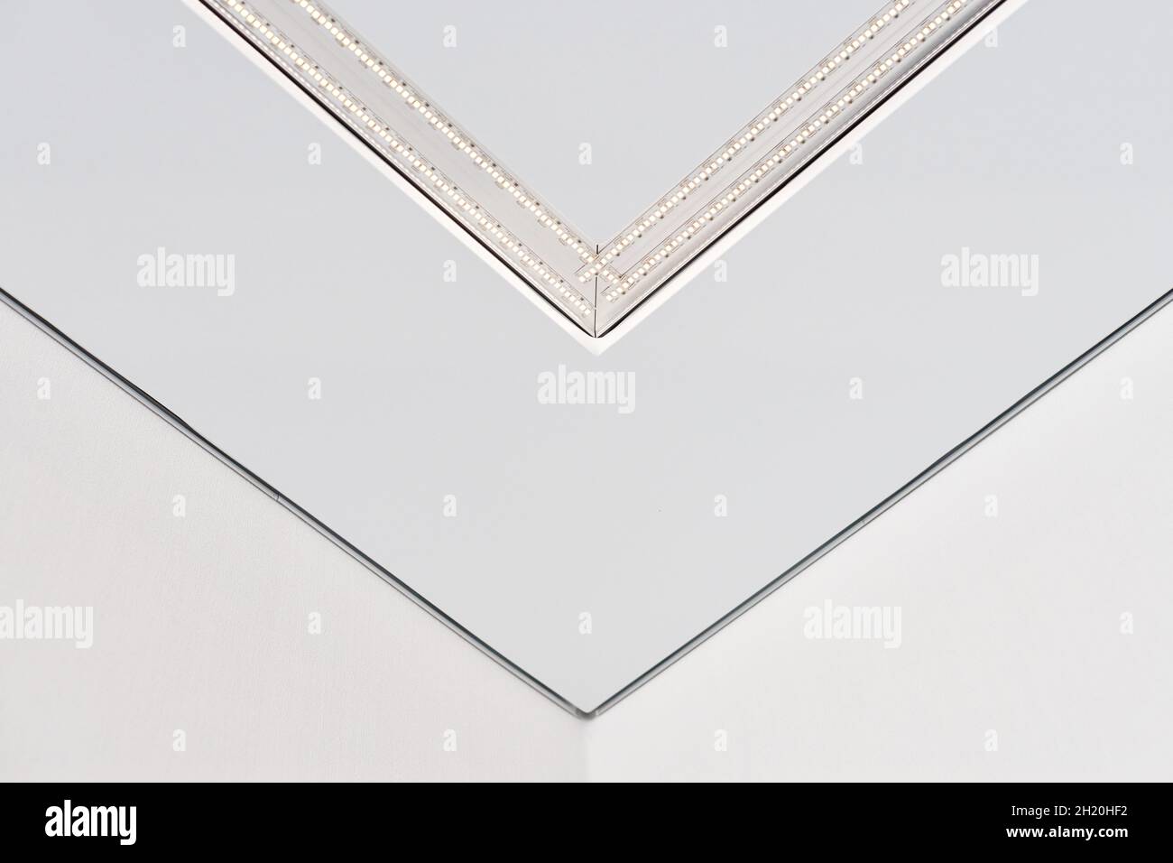 Lampada a striscia a LED con profilo quadrato in alluminio su controsoffitto in casa, frammento, primo piano. Ristrutturazione e ristrutturazione della casa. Energia Foto Stock