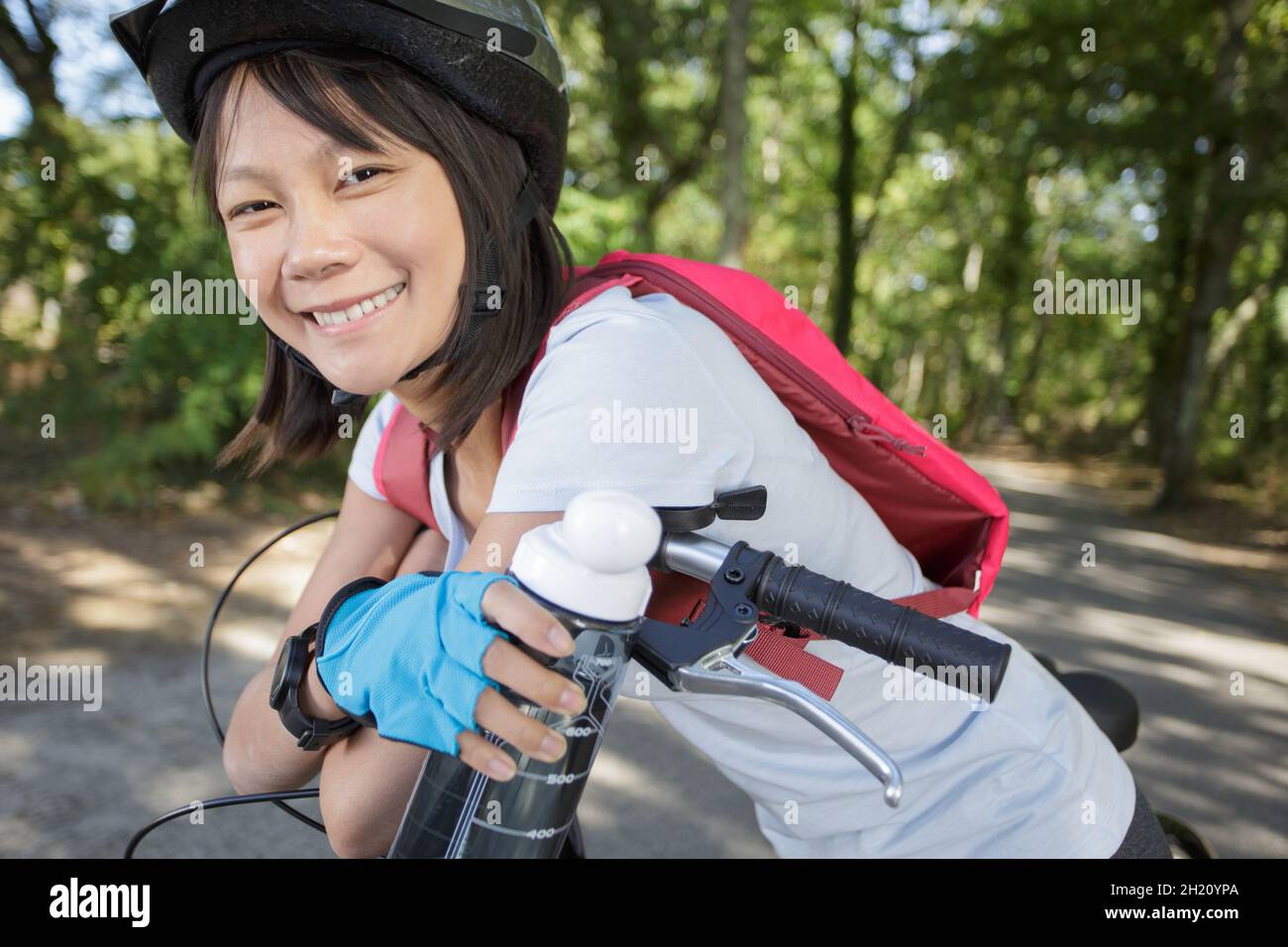 giovane donna che beve acqua in bicicletta Foto Stock