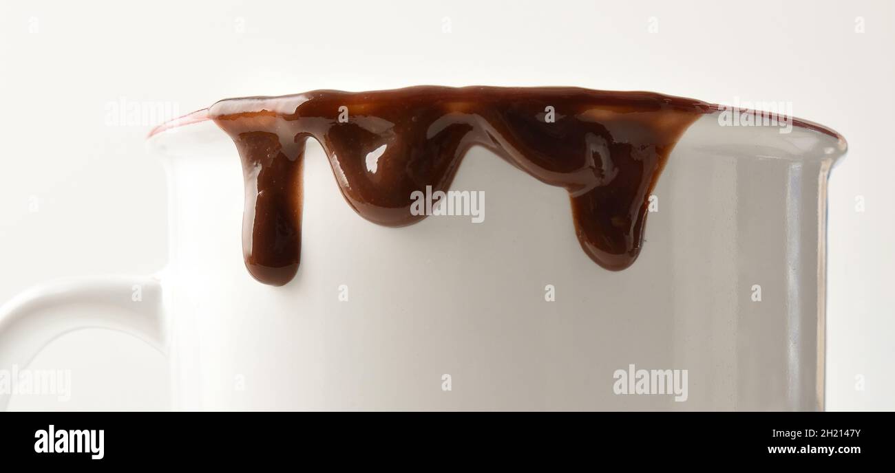 Bordo bianco della tazza con gocce di cioccolato e fondo isolato. Vista frontale. Foto Stock