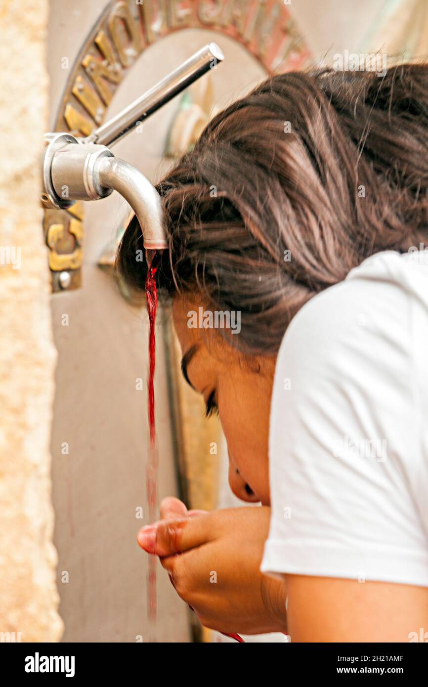 Pellegrini che utilizzano la fontana del vino presso il Bodegas Irache di Ayegui Navarra mentre camminano il Camino de Santiago la via del pellegrinaggio di San Giacomo Foto Stock