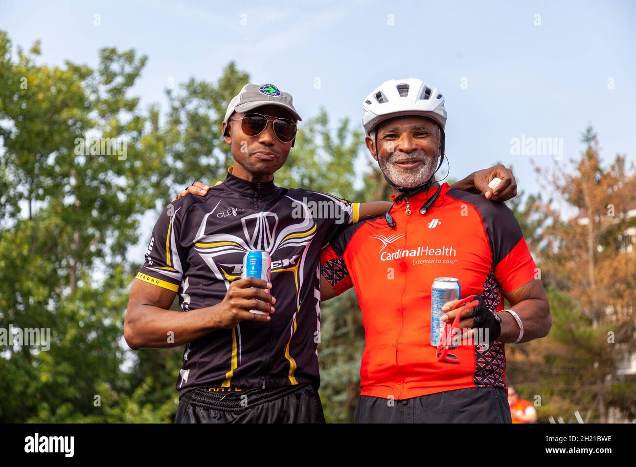 Columbus, OH USA 08-07-2021: Un anziano padre afroamericano e suo figlio cresciuto indossano camicie da bicicletta in un viaggio in bicicletta. Si pongono felicemente come t Foto Stock