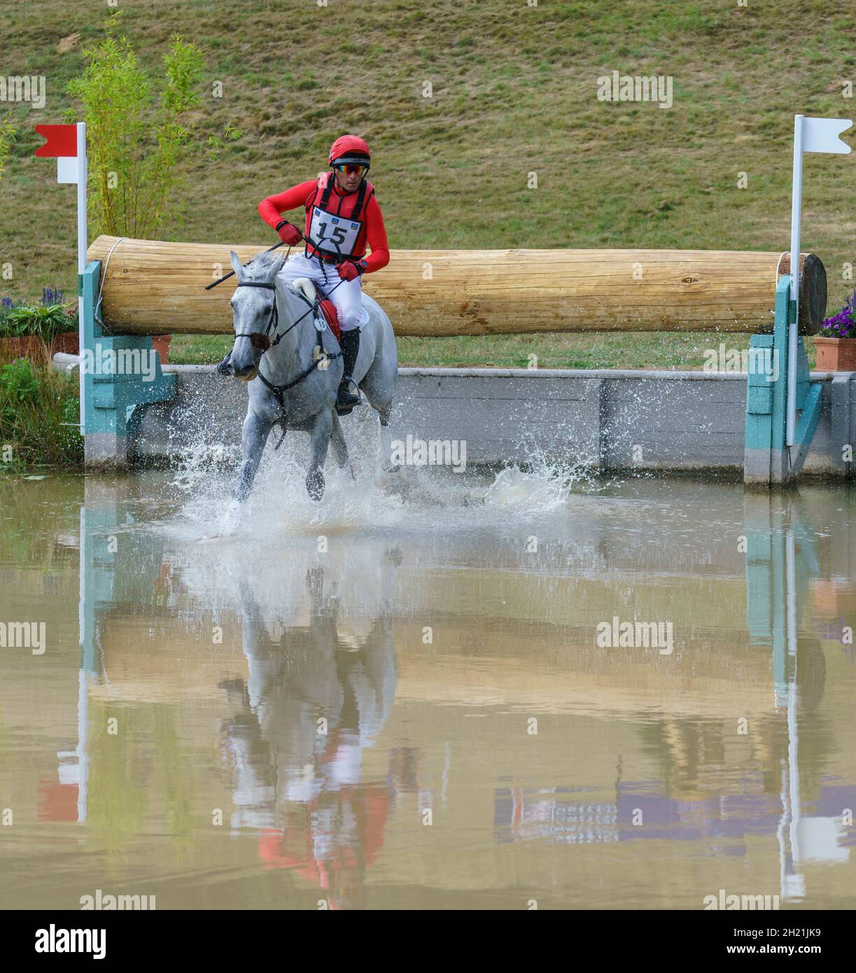 Cavallo e pilota che prende il corso di cross country e salta d'acqua in un'evocante competizione a Gloucestershire, Regno Unito, nel 2018. Foto Stock
