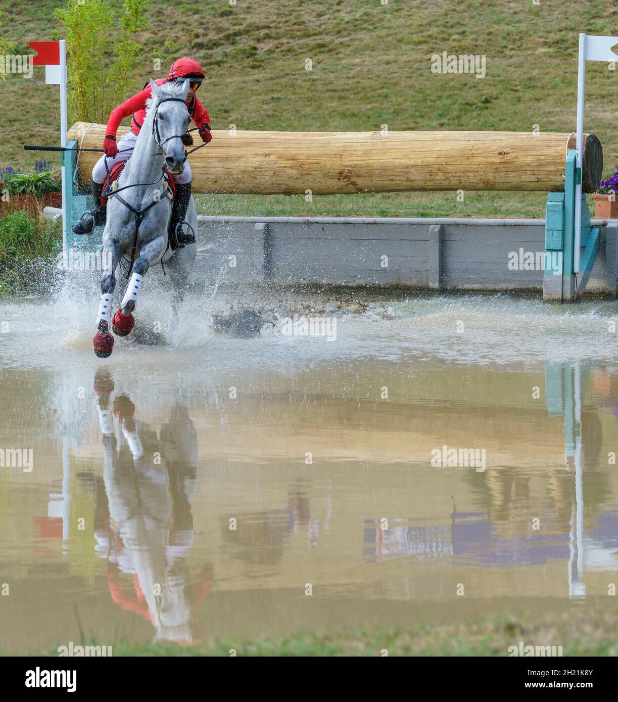 Cavallo e pilota che prende il corso di cross country e salta d'acqua in un'evocante competizione a Gloucestershire, Regno Unito, nel 2018. Foto Stock
