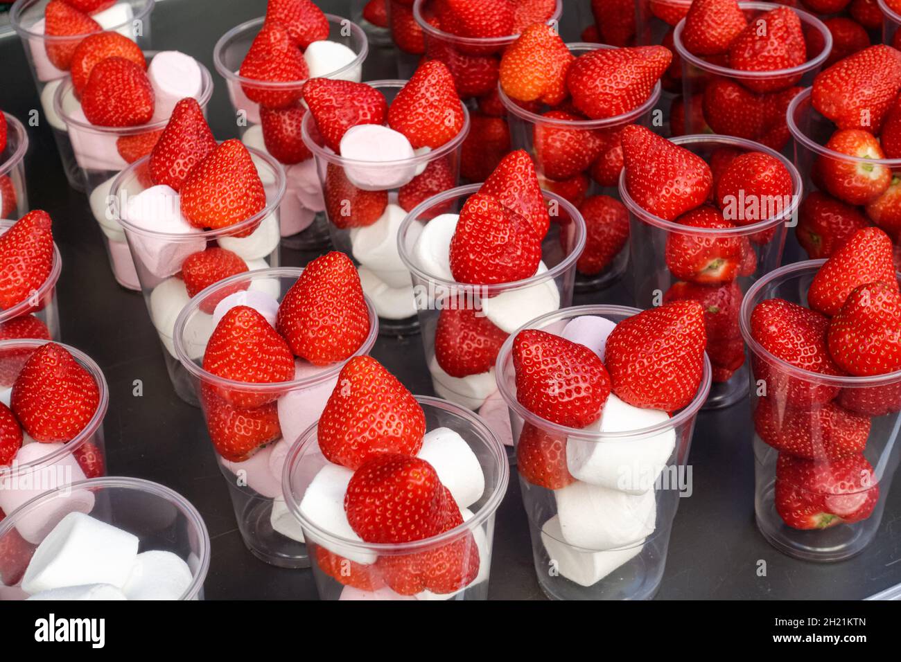 marshmallow e dessert alla fragola in tazze di plastica Foto Stock