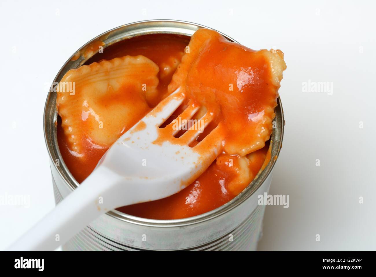 Ravioli in lattina e forchetta di plastica, pasto pronto con forchetta Foto Stock