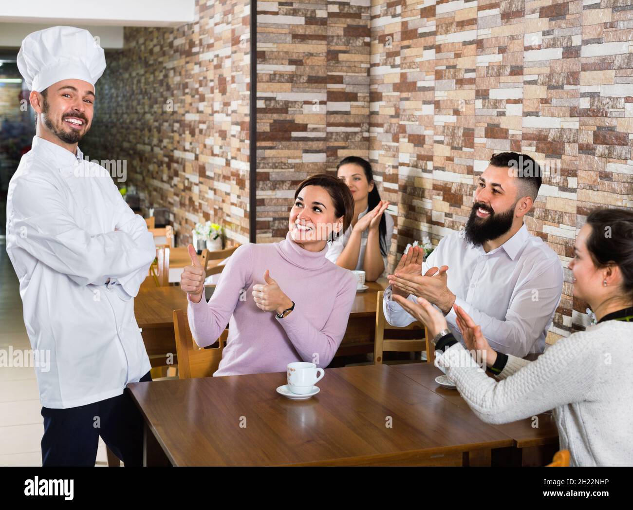 Lo chef felice ascolta le lodi del cibo Foto Stock