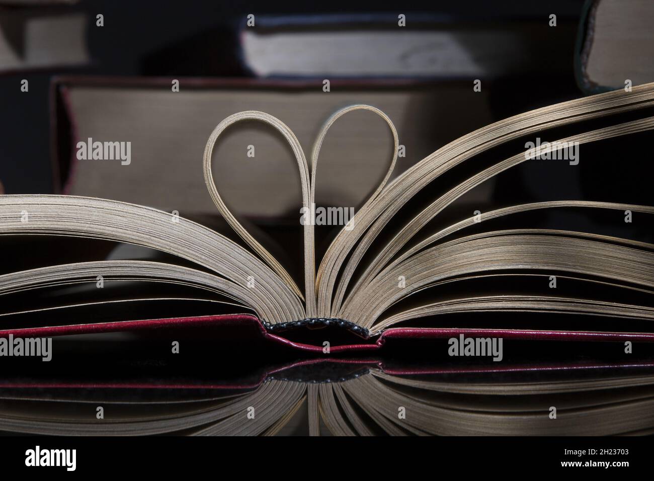 Primo piano delle pagine del libro piegate a forma di un cuore Foto Stock