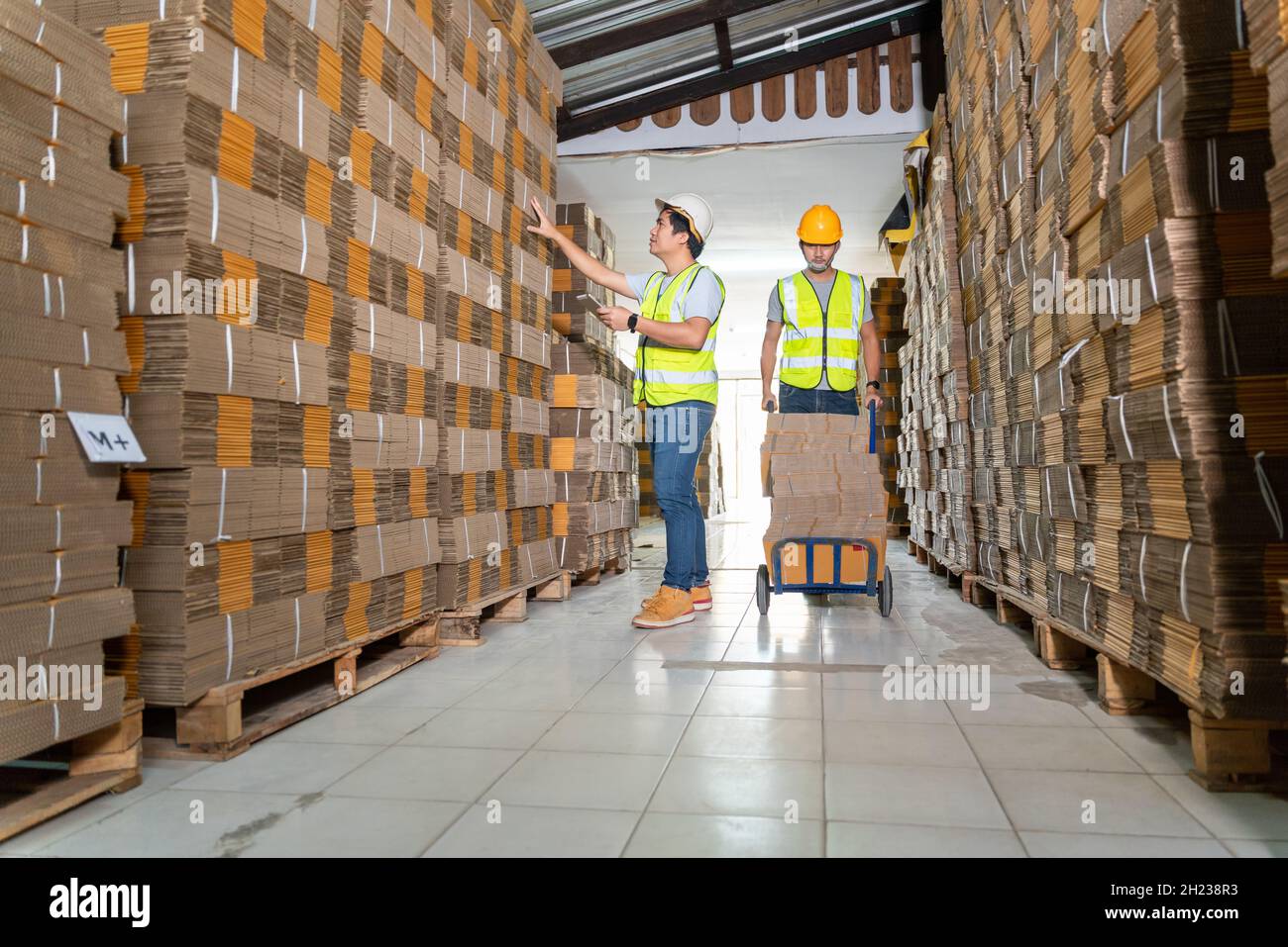 Lavoro di squadra dei lavoratori in magazzino preparare scatole di cartone merci su un pallet in magazzino per la spedizione. Foto Stock