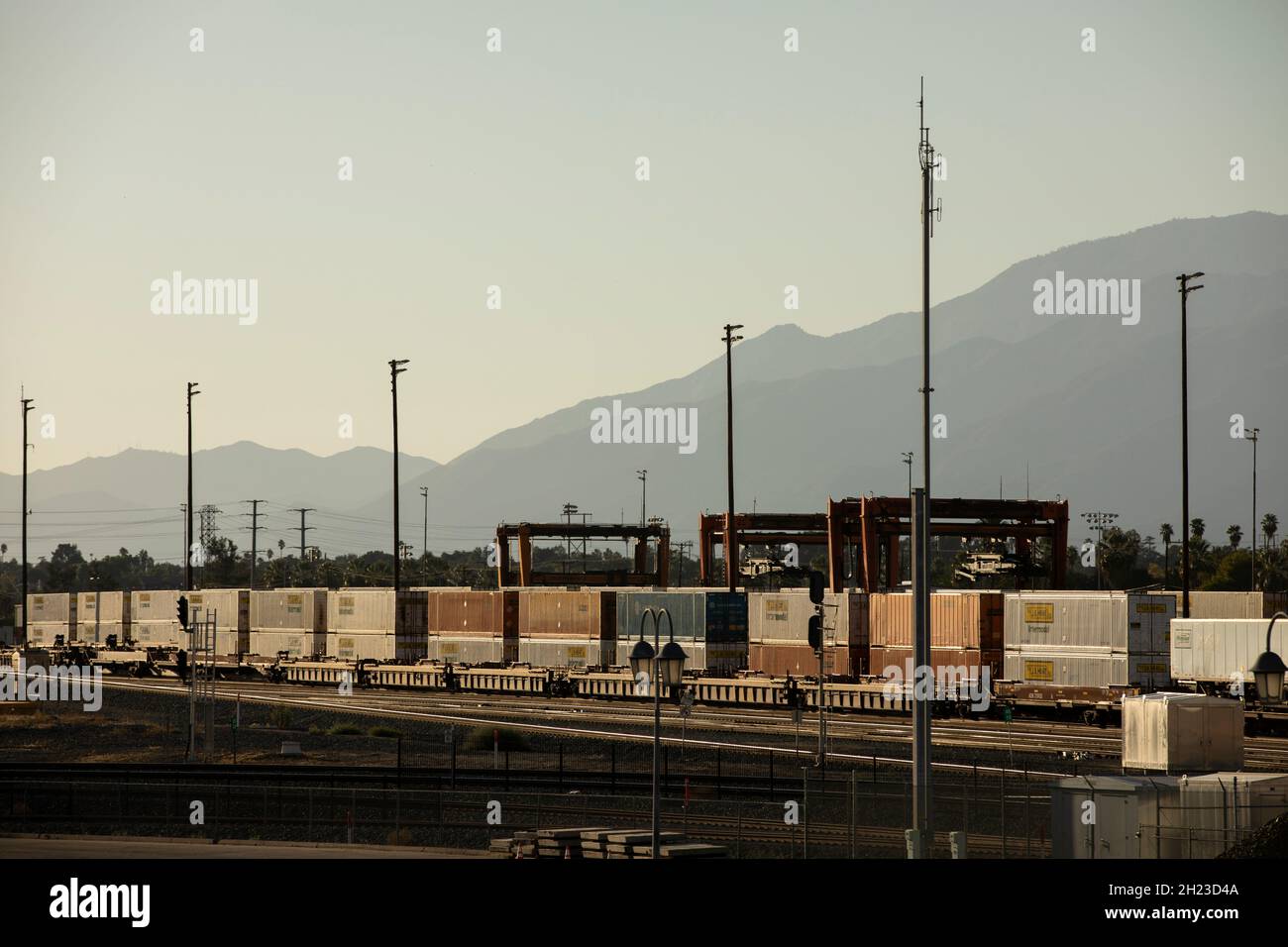 San Bernardino, California, USA - 10 ottobre 2021: Un treno cargo stack nel tardo pomeriggio arriva in una struttura intermodale da scaricare. Foto Stock