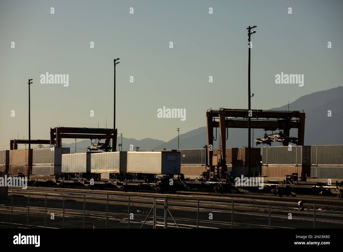 San Bernardino, California, USA - 10 ottobre 2021: Un treno cargo stack nel tardo pomeriggio arriva in una struttura intermodale da scaricare. Foto Stock