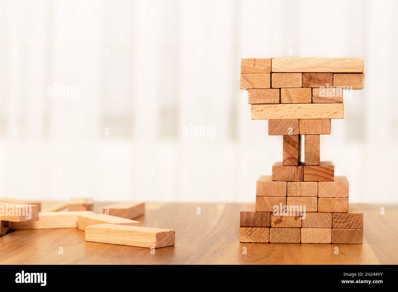 Uomo costruzione blocchi di legno forma di vetro di ore. Concetto di gestione aziendale e temporale. Foto Stock