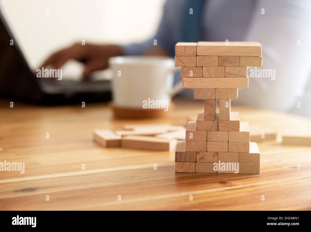 Uomo costruzione blocchi di legno forma di vetro di ore. Concetto di gestione aziendale e temporale. Foto Stock