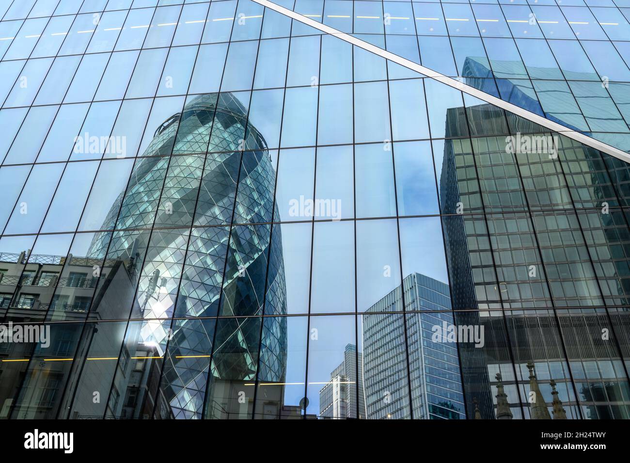 Il Gherkin e altri edifici si riflettono nella facciata di vetro dell'edificio Scalpel a City of London, Inghilterra. Foto Stock