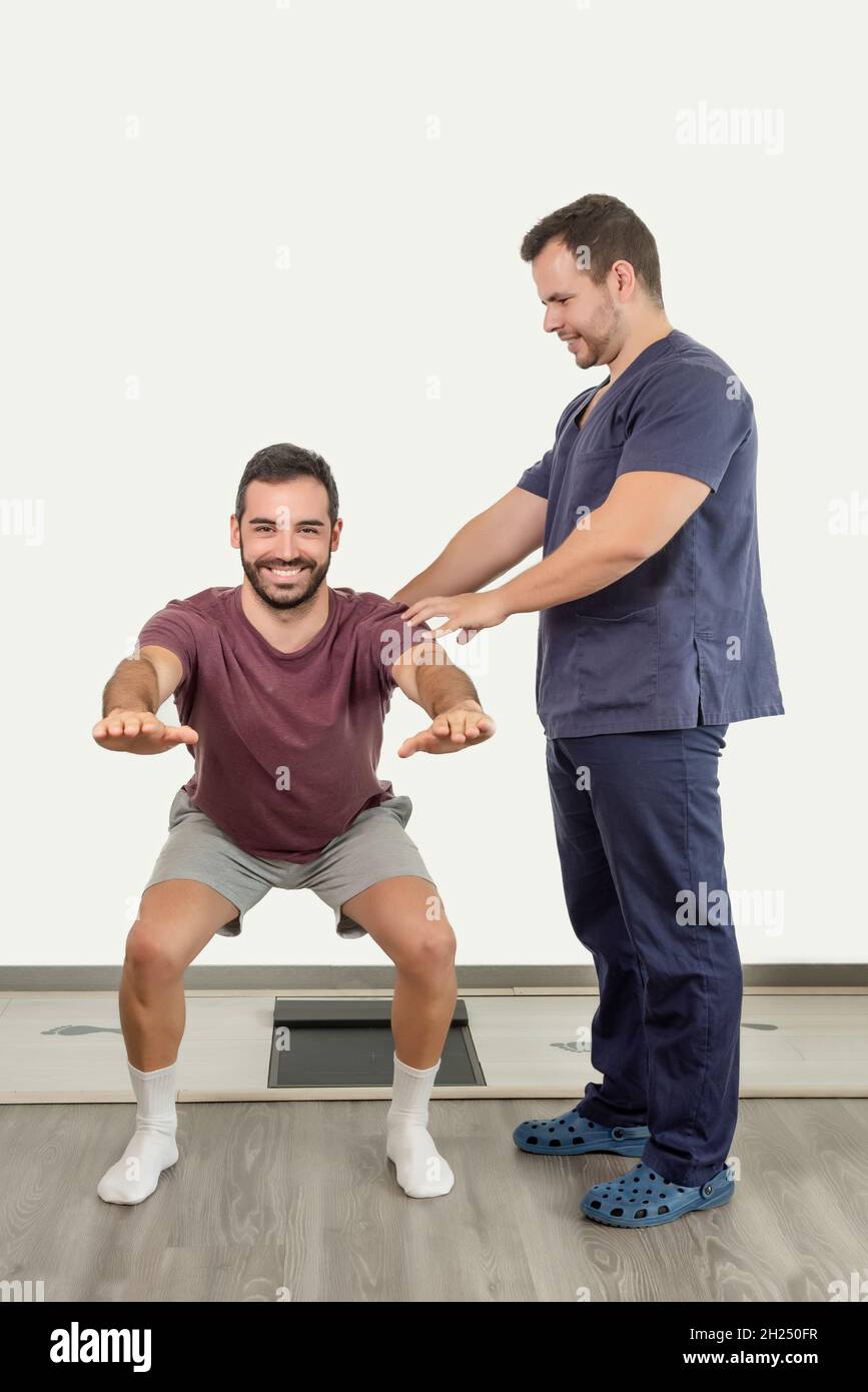 Fisioterapista che istruisce il paziente sulla posizione corretta per la flessione del ginocchio Foto Stock