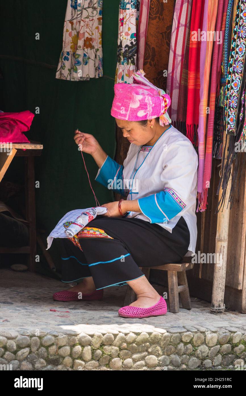 Una minoranza etnica di Zhuang in abbigliamento tradizionale svolge il lavoro di ricovero nel villaggio di Huangluo, Cina. Foto Stock