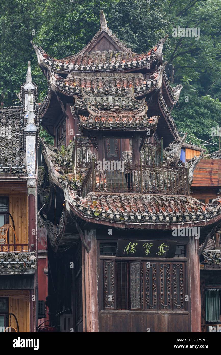 Un edificio stretto con architettura tradizionale con grovaie e tetto di tegole capovolte. Fenghuang, Cina. Foto Stock