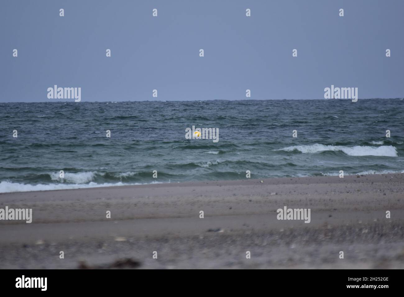 Diversi fuochi di una spiaggia contro l'oceano con un piccolo boa galleggiante Foto Stock