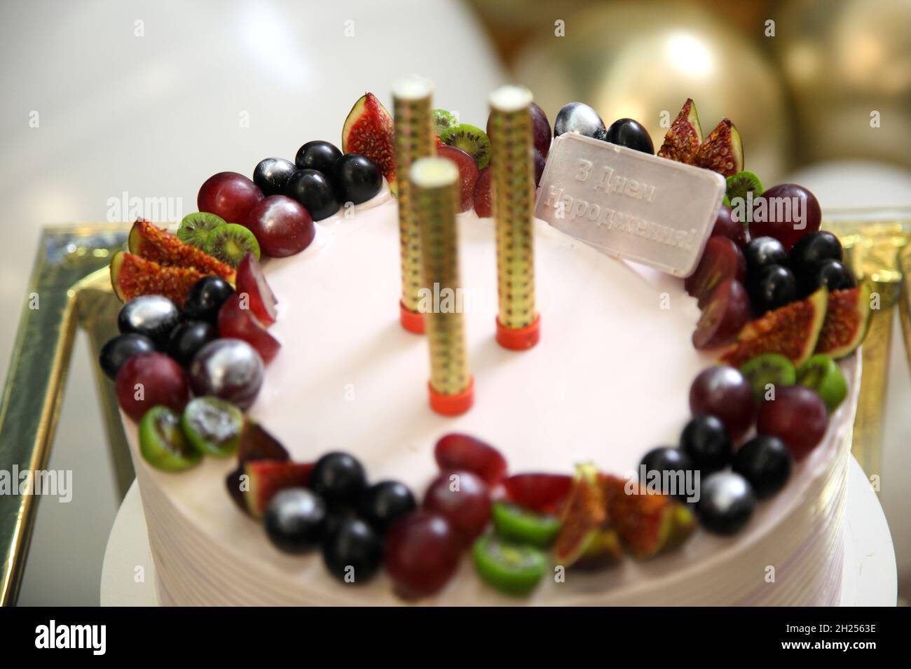 Torta di compleanno con decorazioni. Torta natalizia con frutta e  iscrizione in ucraino Happy Birthday! Foto stock - Alamy