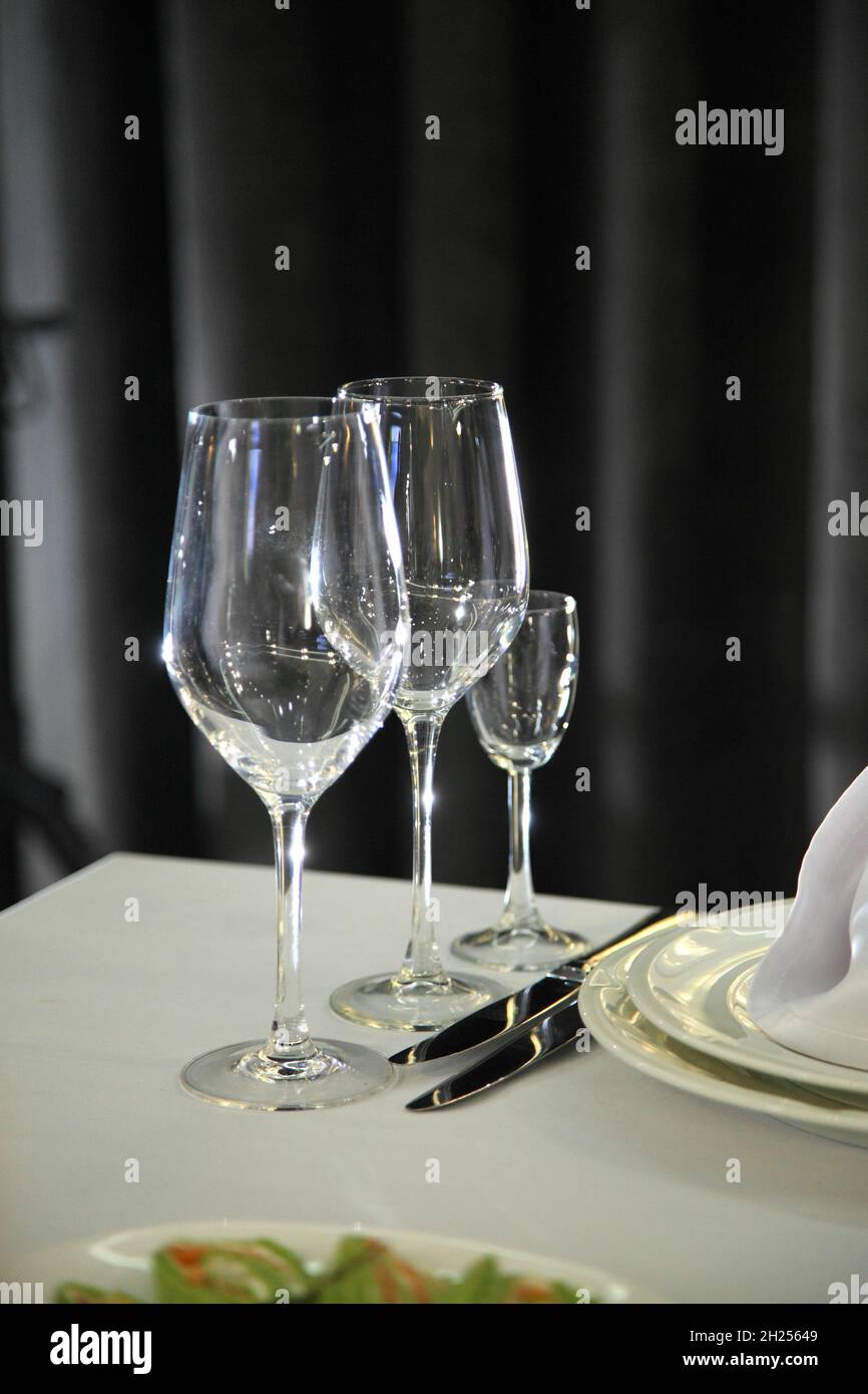 L'impostazione del tavolo nel ristorante. I vini serviti per una cena festiva. Ambiente tavolo in un ristorante moderno. Tavolo da festa decorato. Foto Stock