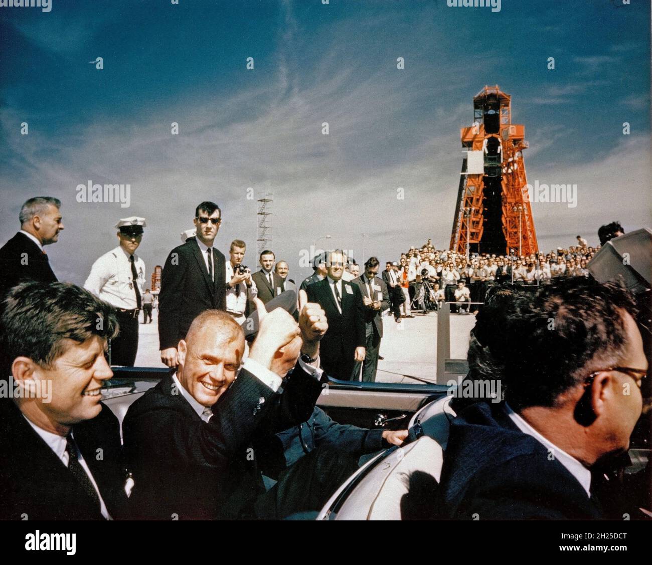 CAPE CANAVERAL Fla. -- l'astronauta John H. Glenn Jr. Dà un doppio pollice-in su mentre lui ed il presidente John F. Kennedy arrivano all'allegato del test missilistico di Cape Canaveral in Florida. La missione di Glenn Mercury Atlas 6 è uscita dal Launch Complex 14, sullo sfondo, il 20 febbraio 1962. Foto Stock