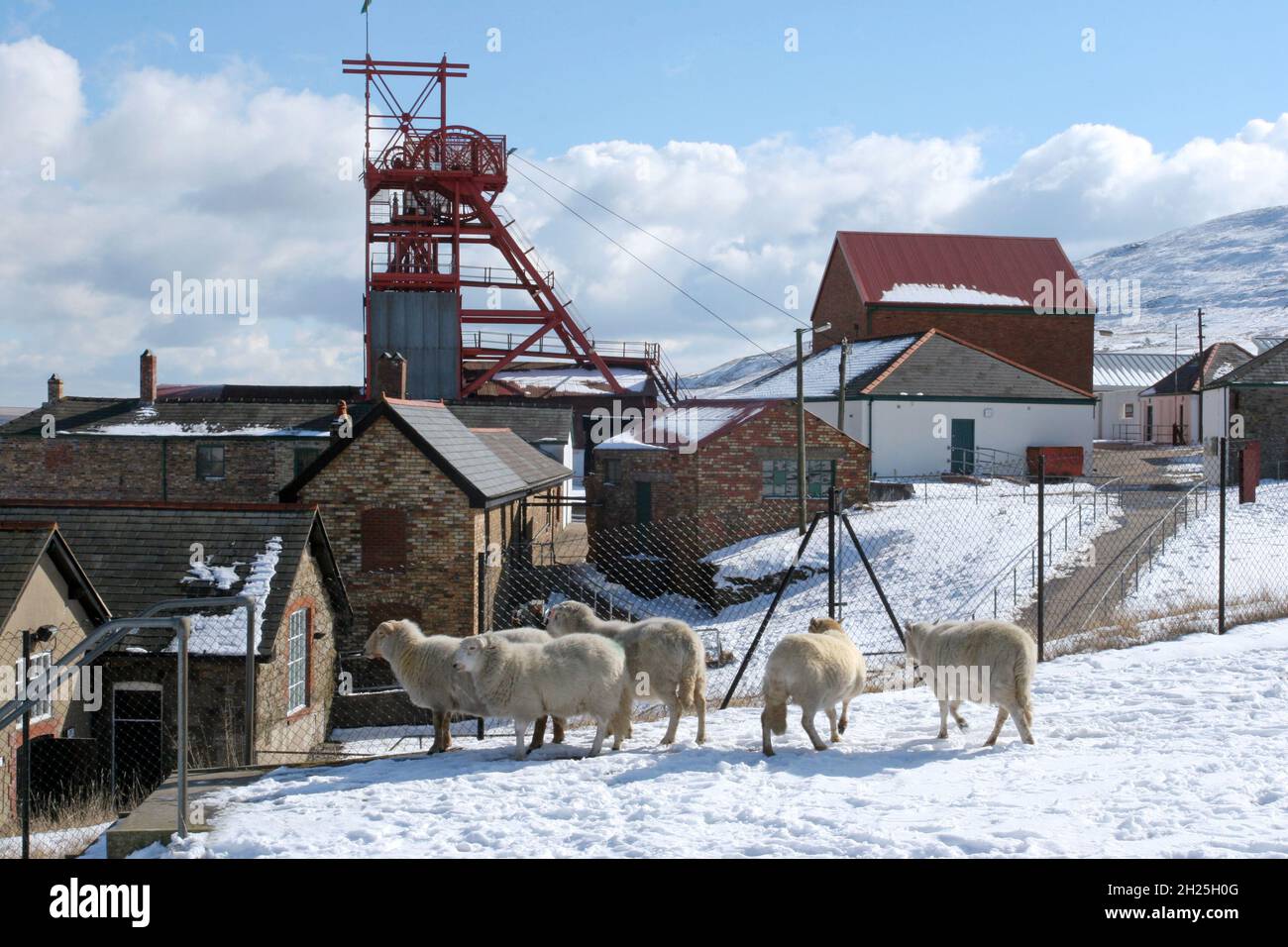 Big Pit museo miniera di carbone in pecore neve mostra torre tortuosa e fuori edifici cielo blu nuvole bianche fluffy, spazio copia, Blaenafon, Galles Regno Unito copia spazio Foto Stock