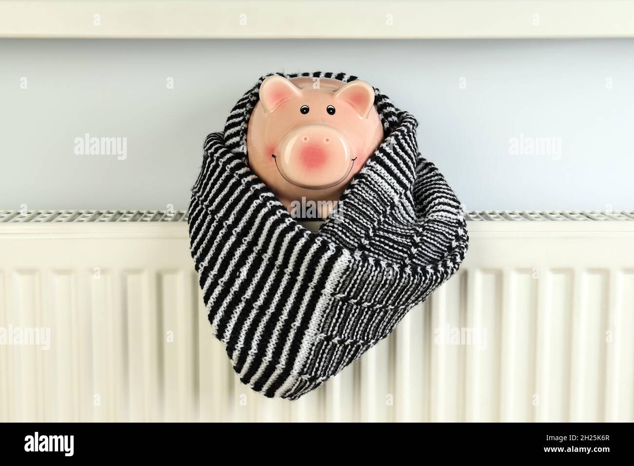 Concetto di stagione di riscaldamento con banco di maialino su radiatore  Foto stock - Alamy