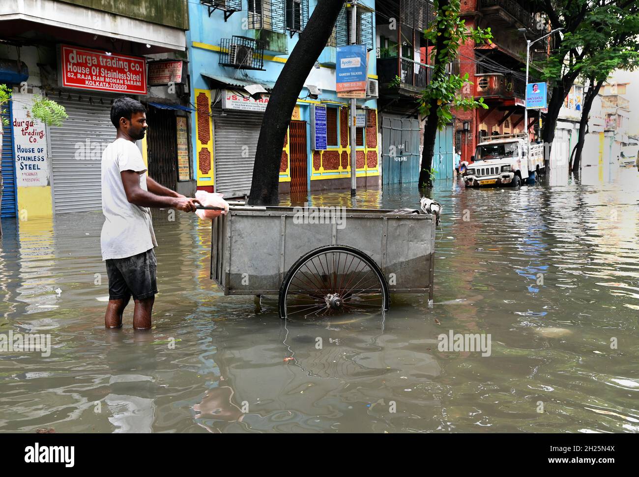 La gente locale che soffre enorme problema per il ceppo di acqua di strada dovuto la pioggia di monsone durante la notte a Kolkata, Bengala occidentale, India. Foto Stock