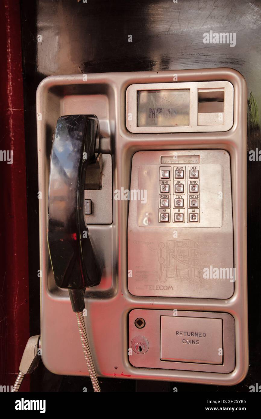 telefono pubblico britannico a pagamento all'interno di una cassetta telefonica rossa Foto Stock