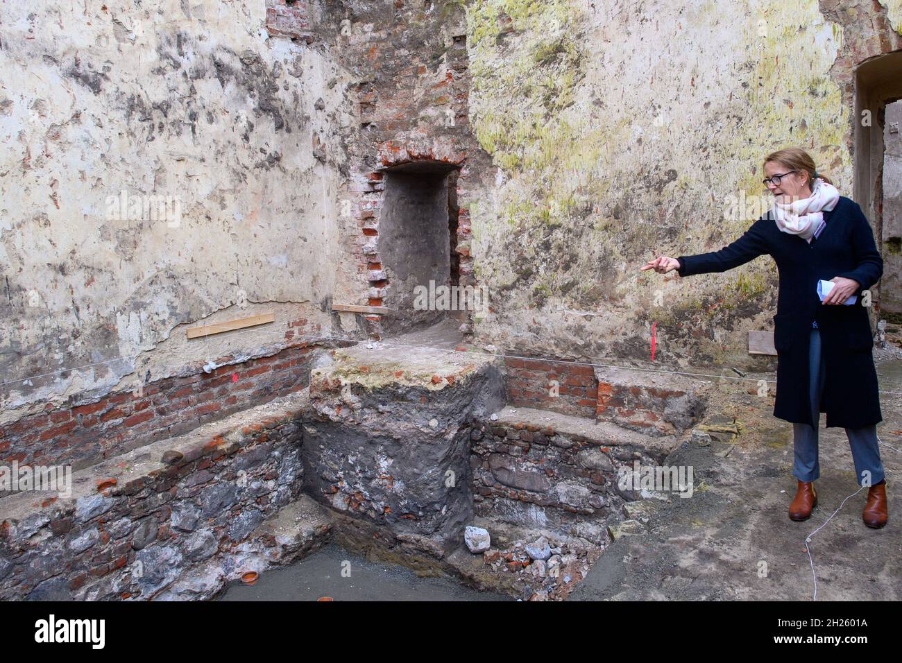 Zerbst, Germania. 20 Ott 2021. Dietlind Paddenberg dal Sassonia-Anhalt Ufficio di Stato per la conservazione dei monumenti e Archeologia punti alla zona scavata nella cantina del Castello di Zerbst. Nelle macerie dello scavo, gli archeologi dell'Ufficio di Stato Sassonia-Anhalt per la conservazione dei monumenti e l'Archeologia avevano trovato numerosi reperti di diverse epoche. Credit: Klaus-Dietmar Gabbert/dpa-Zentralbild/ZB/dpa/Alamy Live News Foto Stock