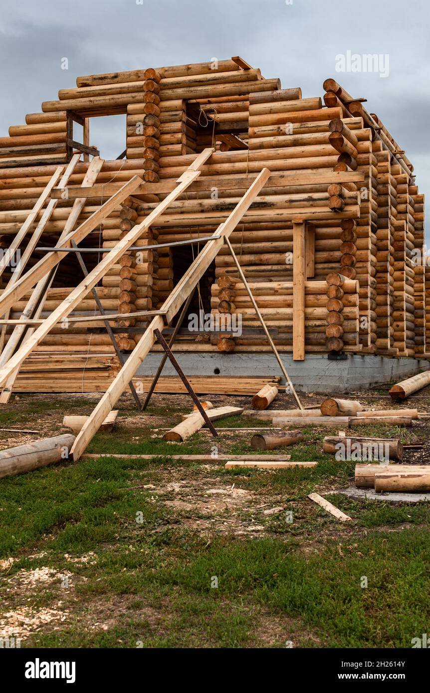 una casa di tronchi in costruzione con un dispositivo per il sollevamento di tronchi. Foto di alta qualità Foto Stock
