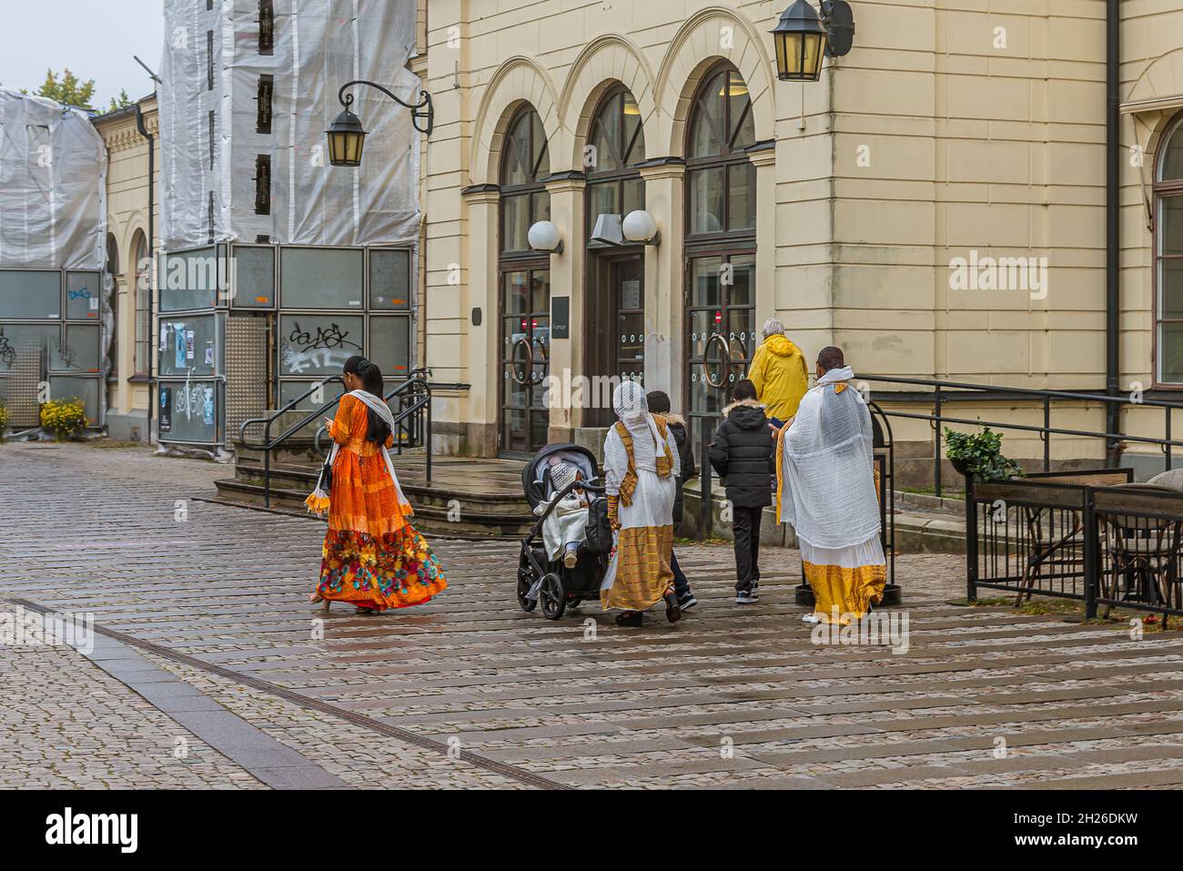 Gruppo etnico in lunghe gonne colorate che camminano di fronte alla stazione centrale di Lund, Svezia, 11 settembre 2021 Foto Stock
