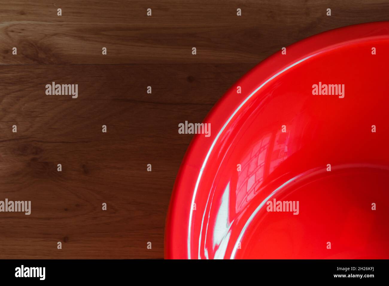 Bacino rosso vuoto su sfondo di legno. Foto Stock