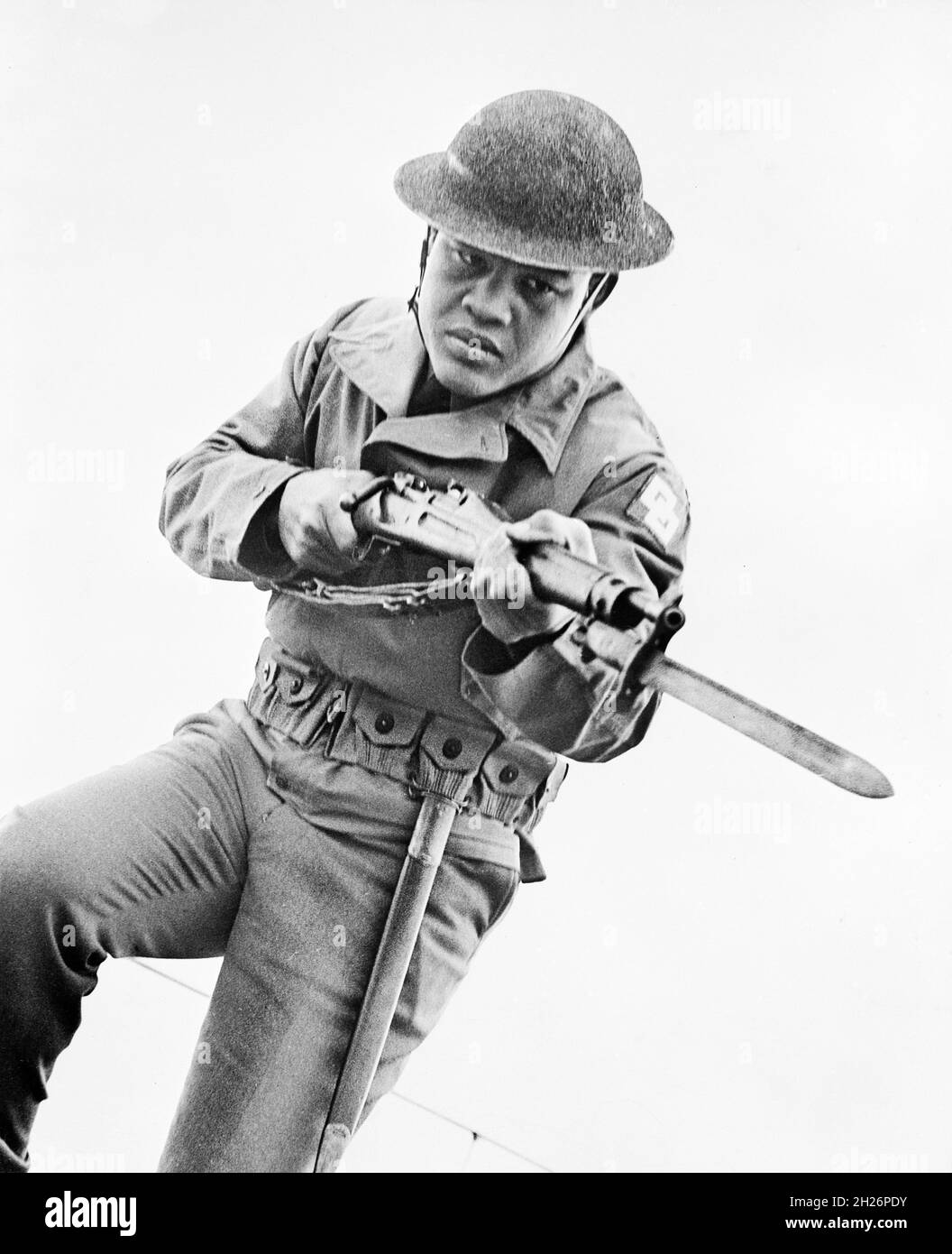 American Professional Boxer Joe Louis (1914-1981), ritratto di tre quarti di lunghezza in uniforme militare, carica con Bayonet, Ufficio americano delle informazioni di guerra, 1942 Foto Stock