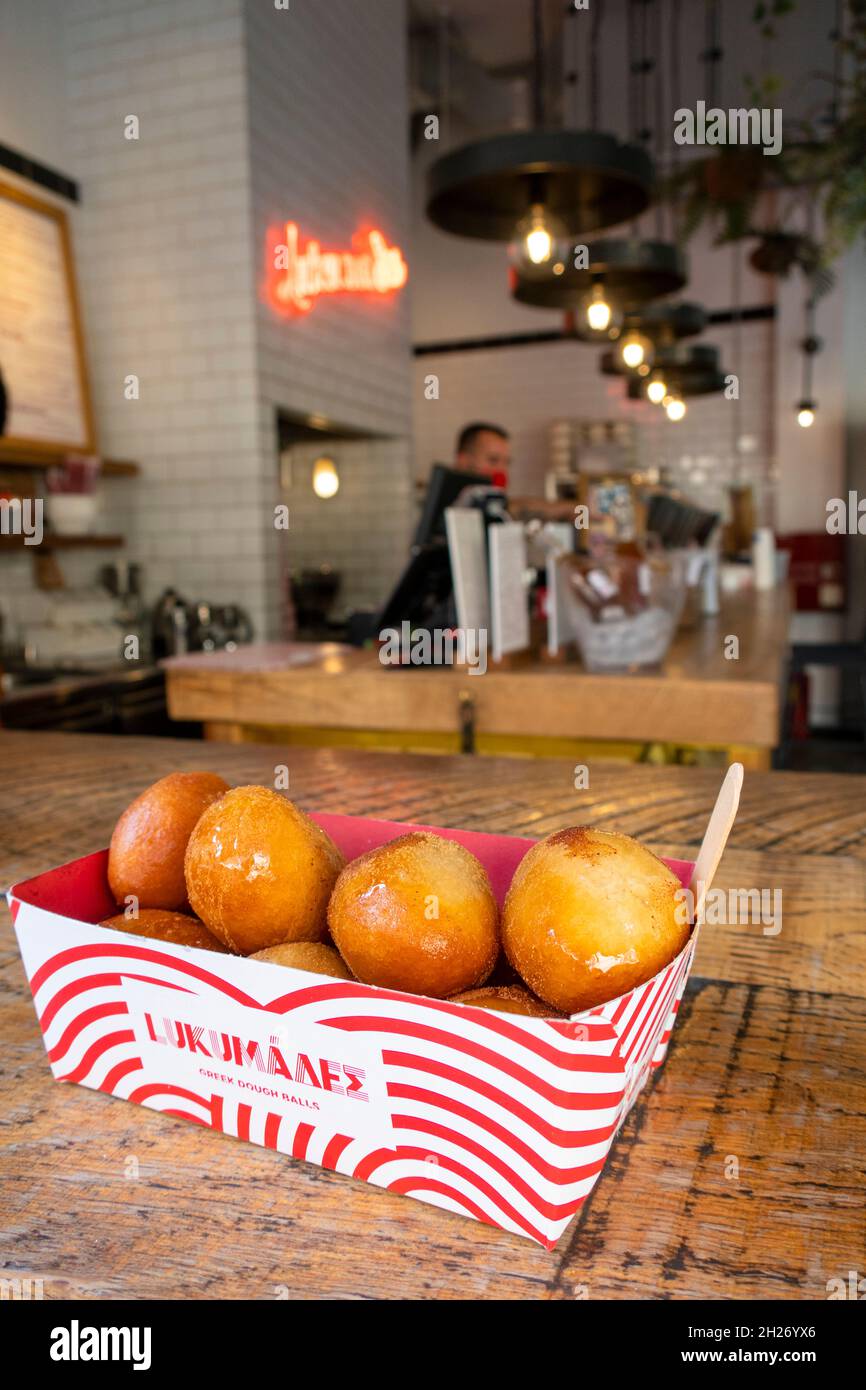 Il famoso negozio di snack Lukumades, che rende le palle fritte ricoperte da una varietà di sapori in via Aghias Irinis ad Atene Foto Stock