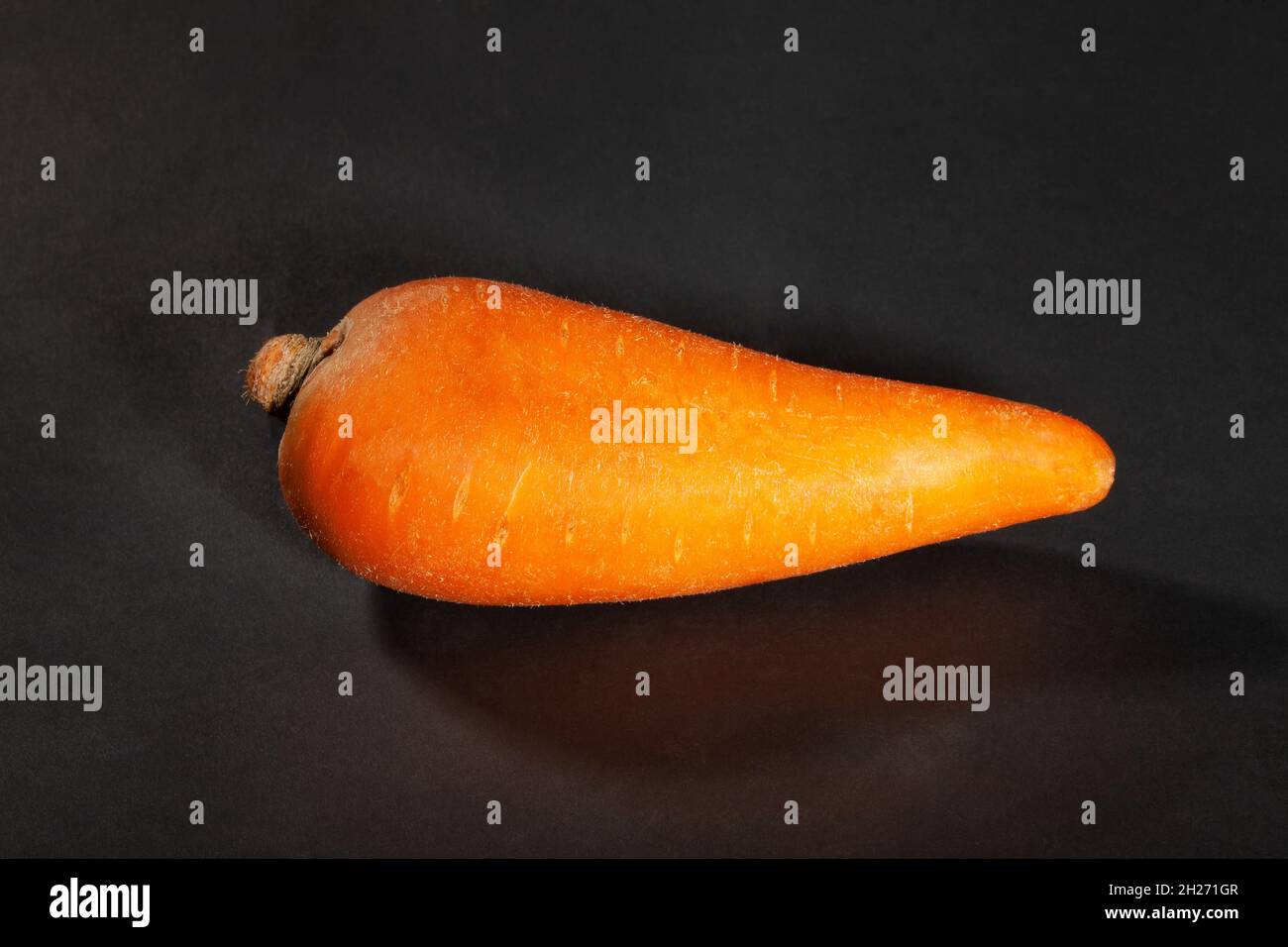 una carota su sfondo nero Foto Stock