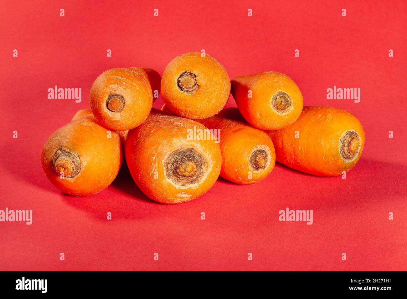mucchio di carote su sfondo rosso Foto Stock