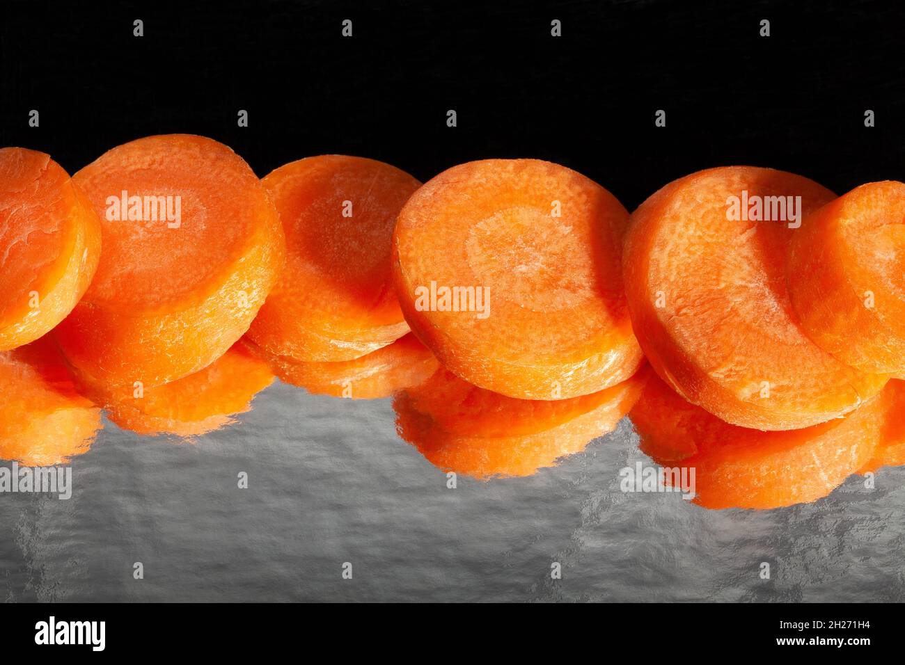carota tagliata a specchio su sfondo nero Foto Stock