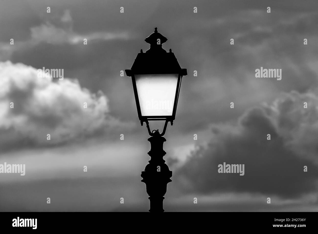Lampione vecchio stile contro il cielo nuvoloso (bianco e nero) Foto Stock