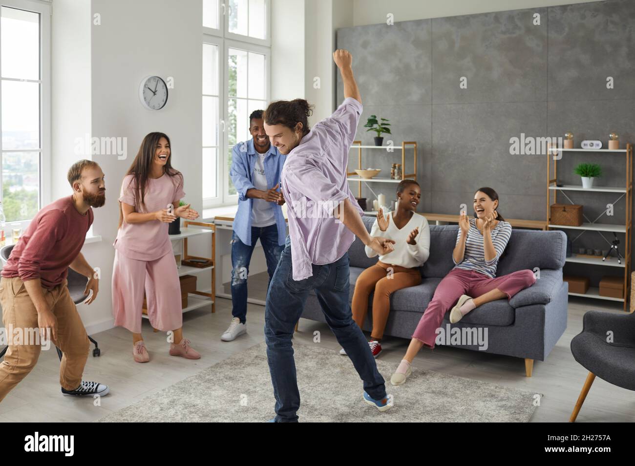 Gruppo di giovani amici polietnici felici che ballano e si divertono in una festa a casa Foto Stock