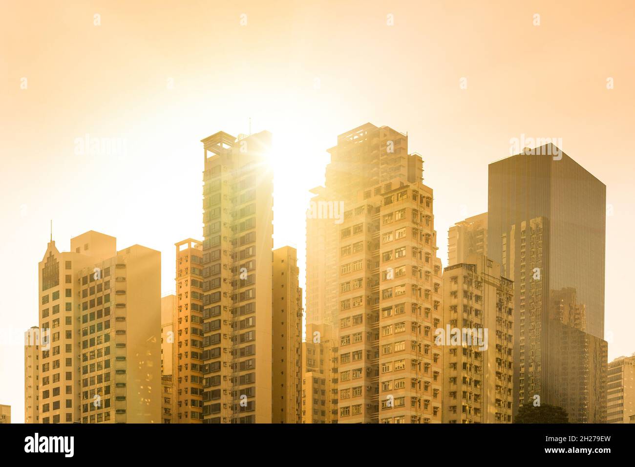 Tramonto dietro lo skyline degli edifici di appartamenti nel quartiere residenziale di Chung WAN nel centro di Hong Kong, Cina. Foto Stock