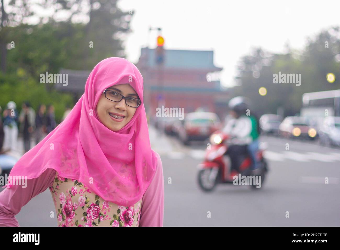 Ritratto di bella giovane musulmana asiatica indossando hijab e occhiali in via di Kyoto. Faccia sorridente alla macchina fotografica con espressione felice. Foto Stock